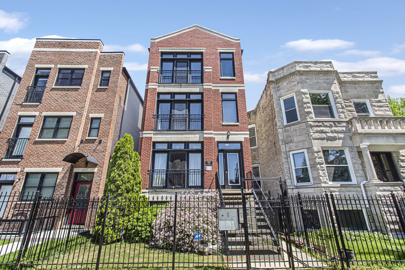 a front view of a residential apartment building with a yard