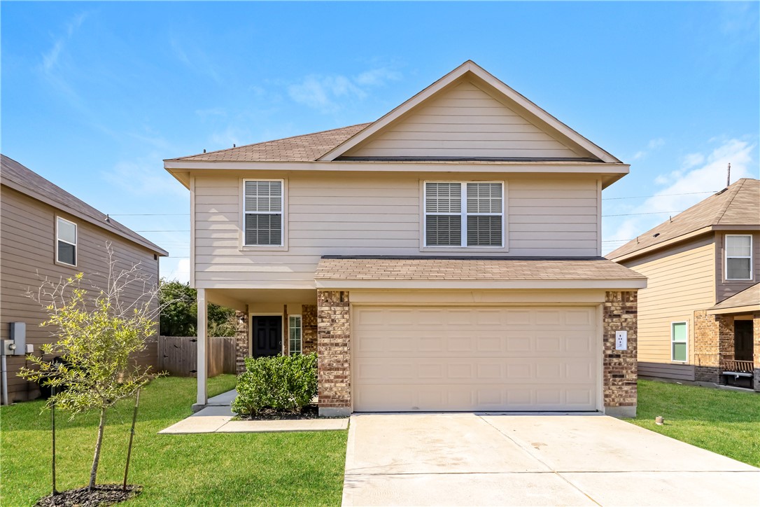 a front view of a house with a yard and garage