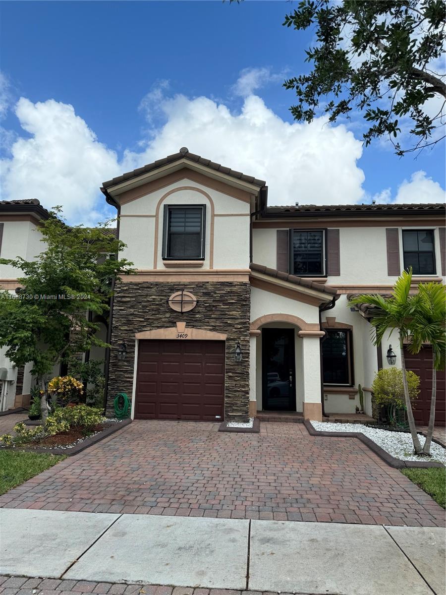 a front view of a house with a yard and garage