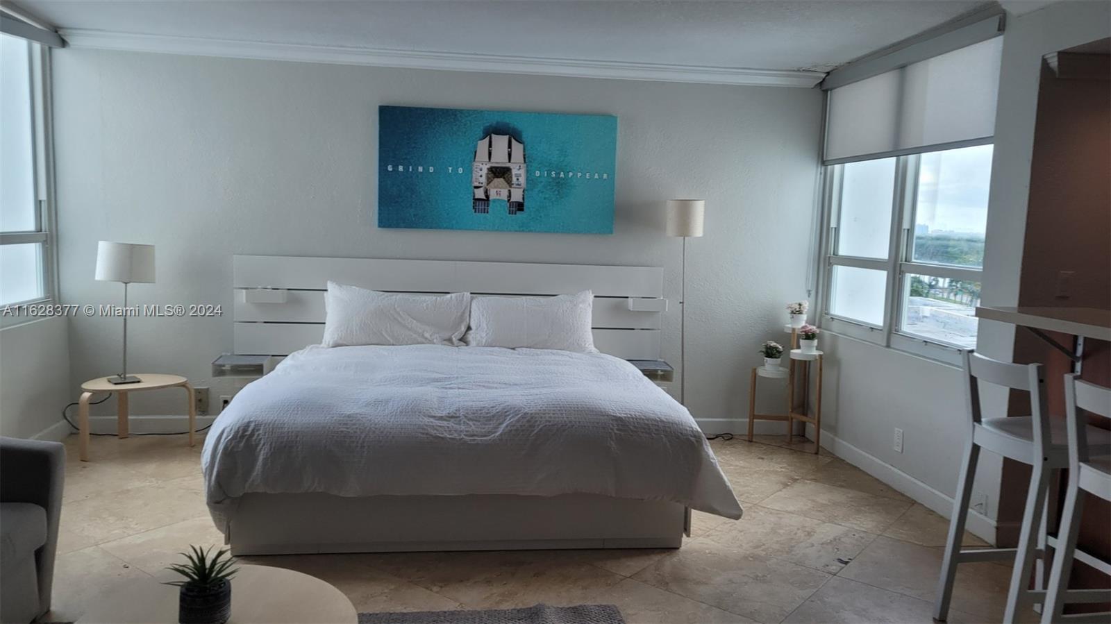 a bedroom with a bed and a painting on the wall