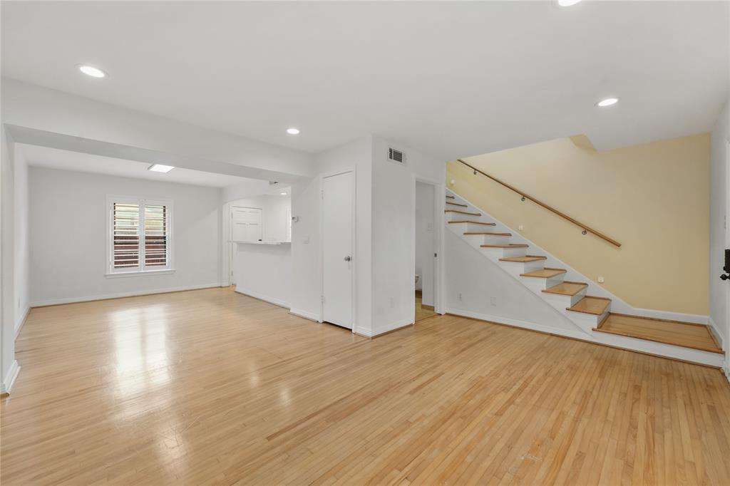 an empty room with wooden floor and staircase