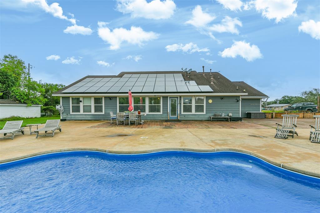 a view of a house with swimming pool and sitting area