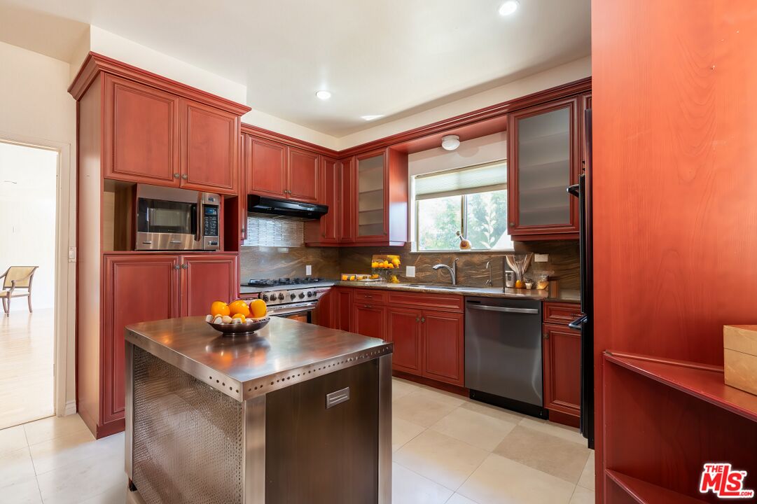 a kitchen with granite countertop a sink stove and refrigerator