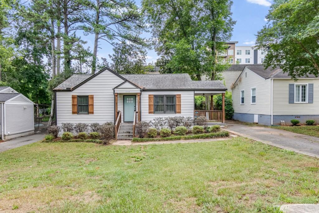 a front view of a house with a yard and trees