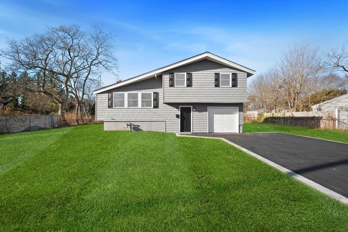 Split level home featuring a front yard and a garage