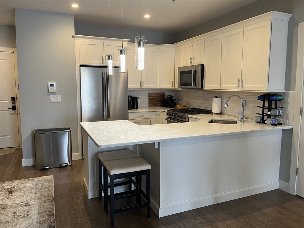 a kitchen with a sink a microwave a refrigerator and cabinets