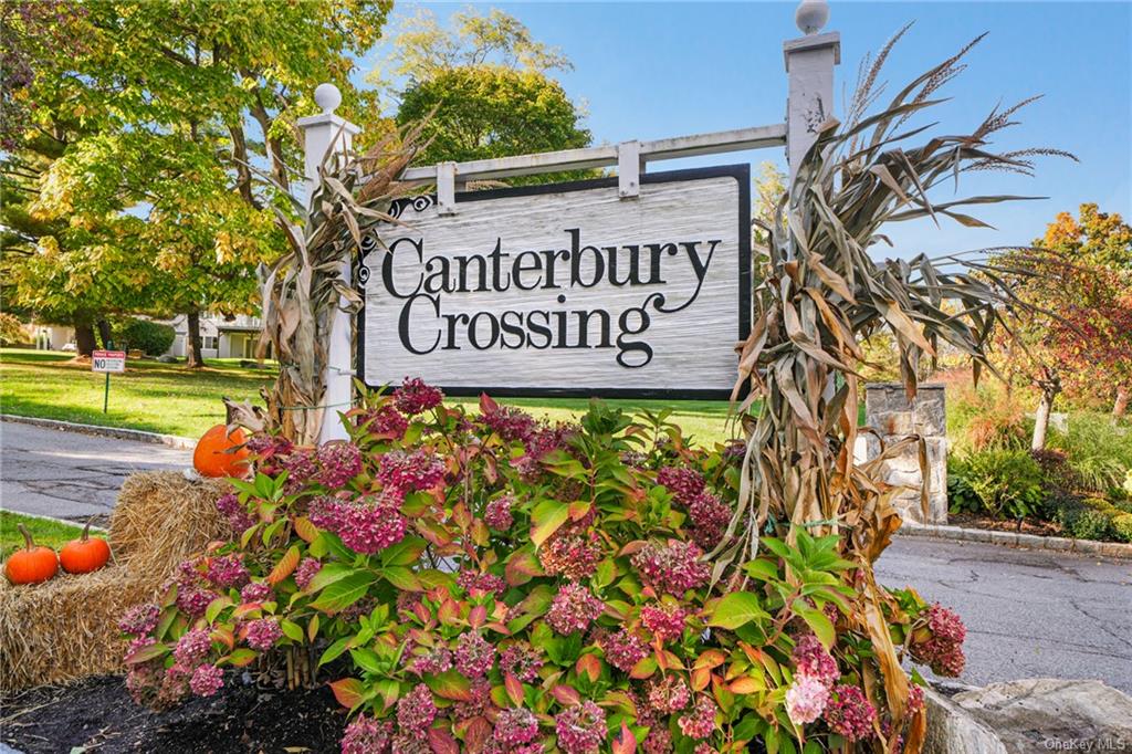 Community / neighborhood sign featuring a lawn