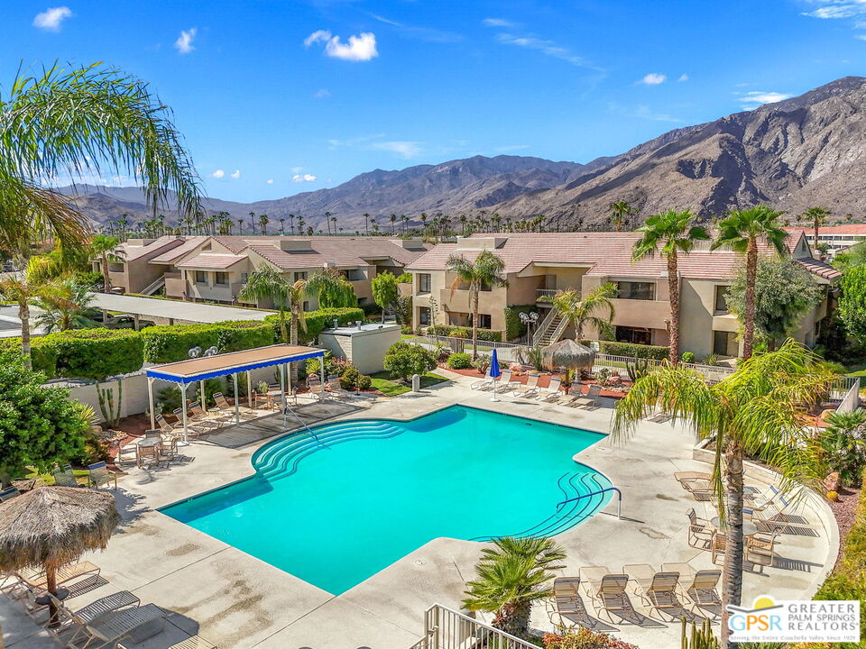 a view of swimming pool with outdoor seating and a garden