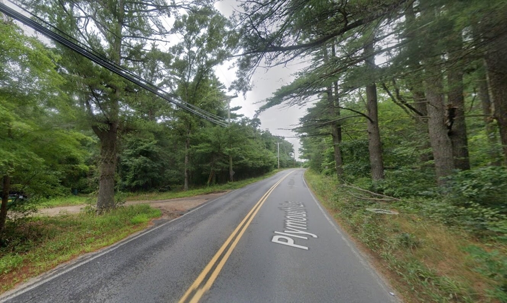 a view of a street with a trees in the background