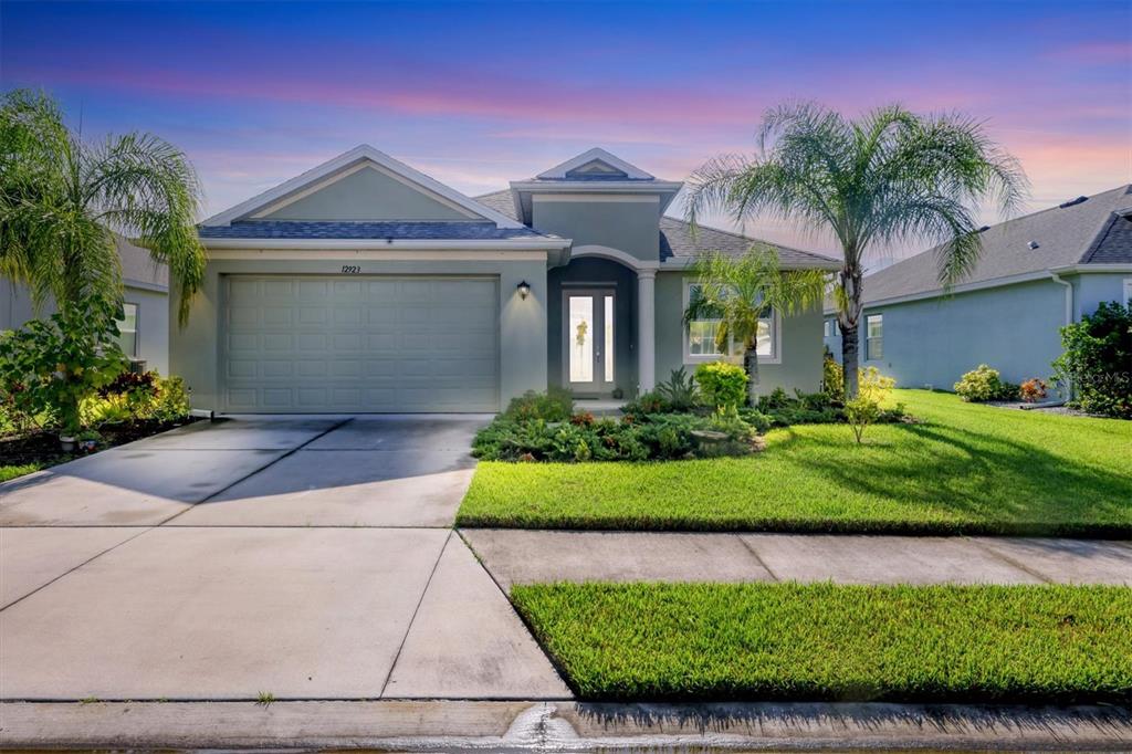 a front view of a house with a yard and potted plants