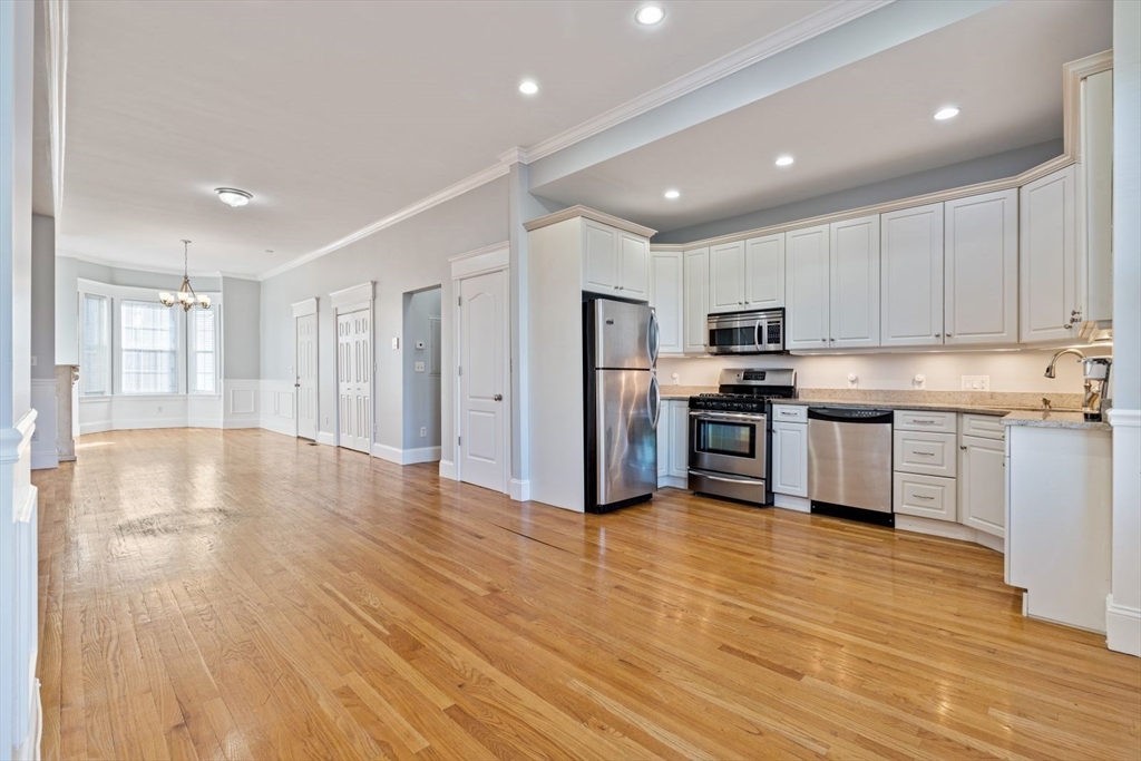 a kitchen with stainless steel appliances granite countertop a refrigerator and a stove top oven