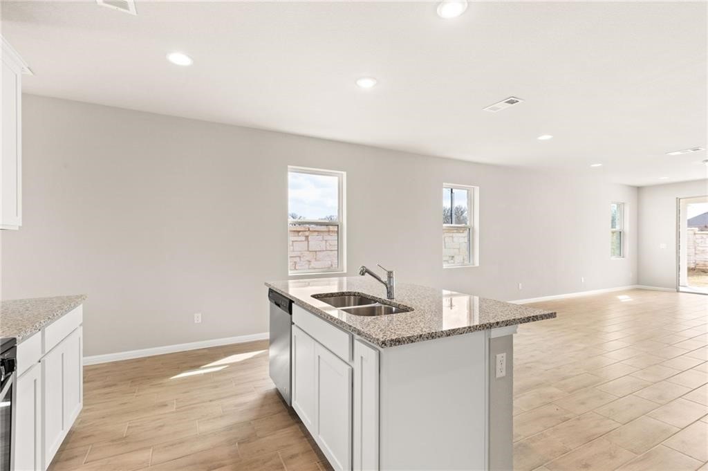 a kitchen with granite countertop a sink and a stove top oven