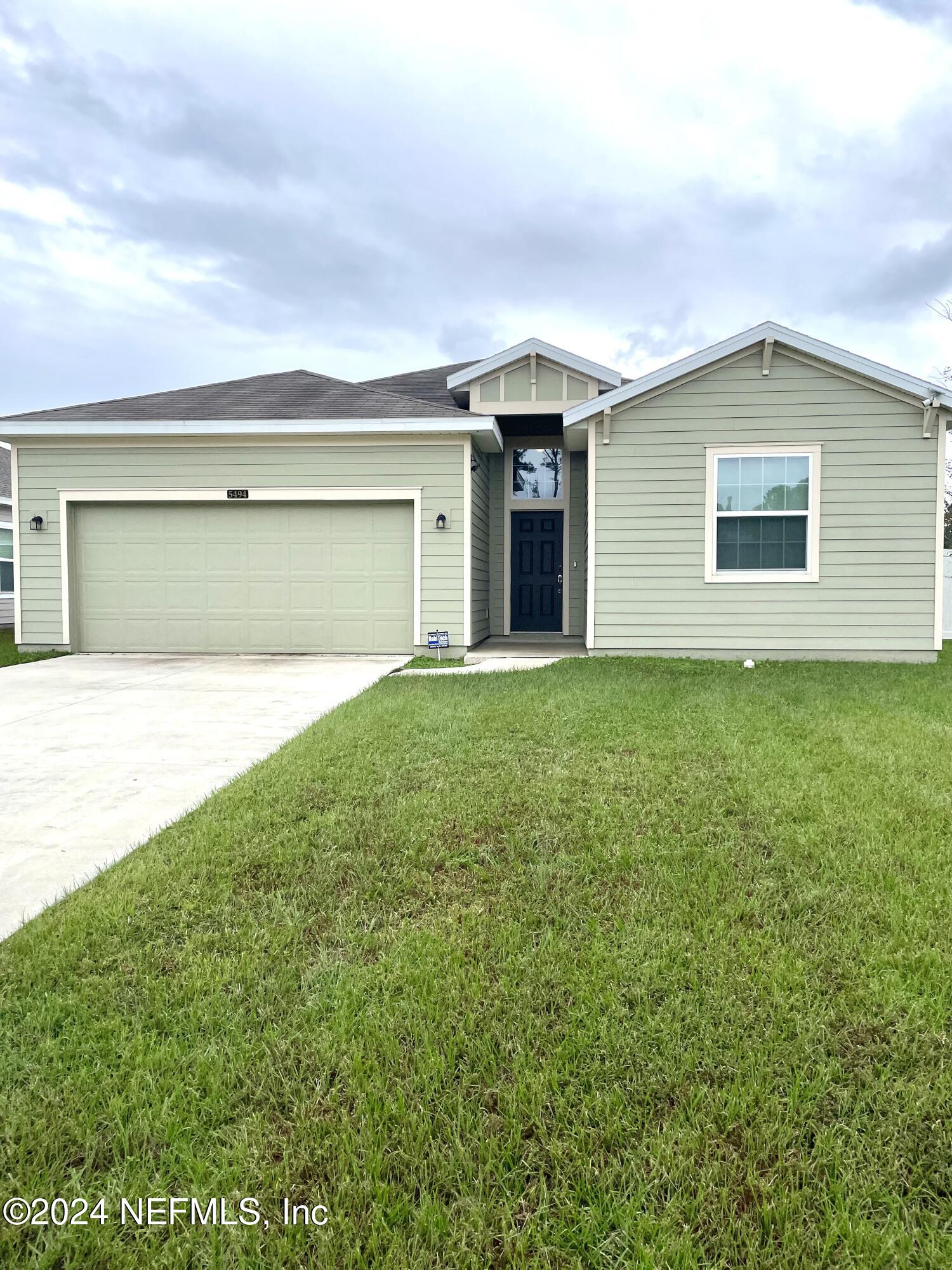 a front view of house with yard and garage