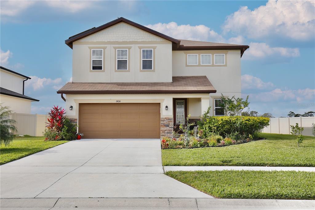 a front view of a house with a yard and garage