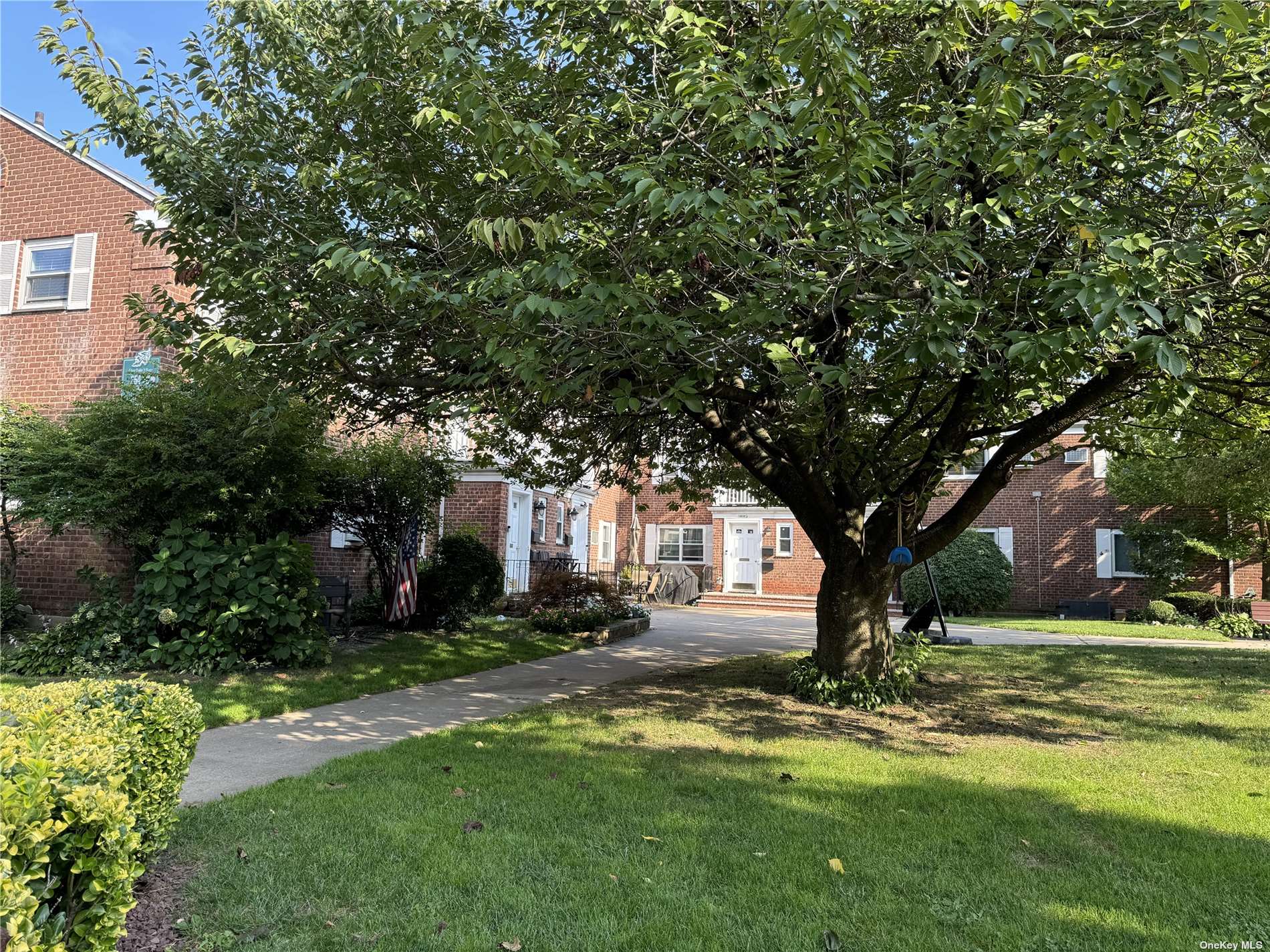 a front view of a house with a yard garage and tree