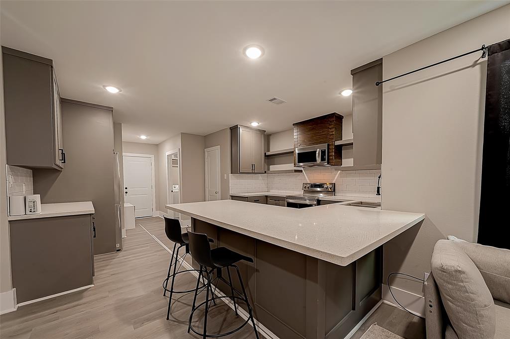 a kitchen with stainless steel appliances a microwave sink refrigerator and cabinets