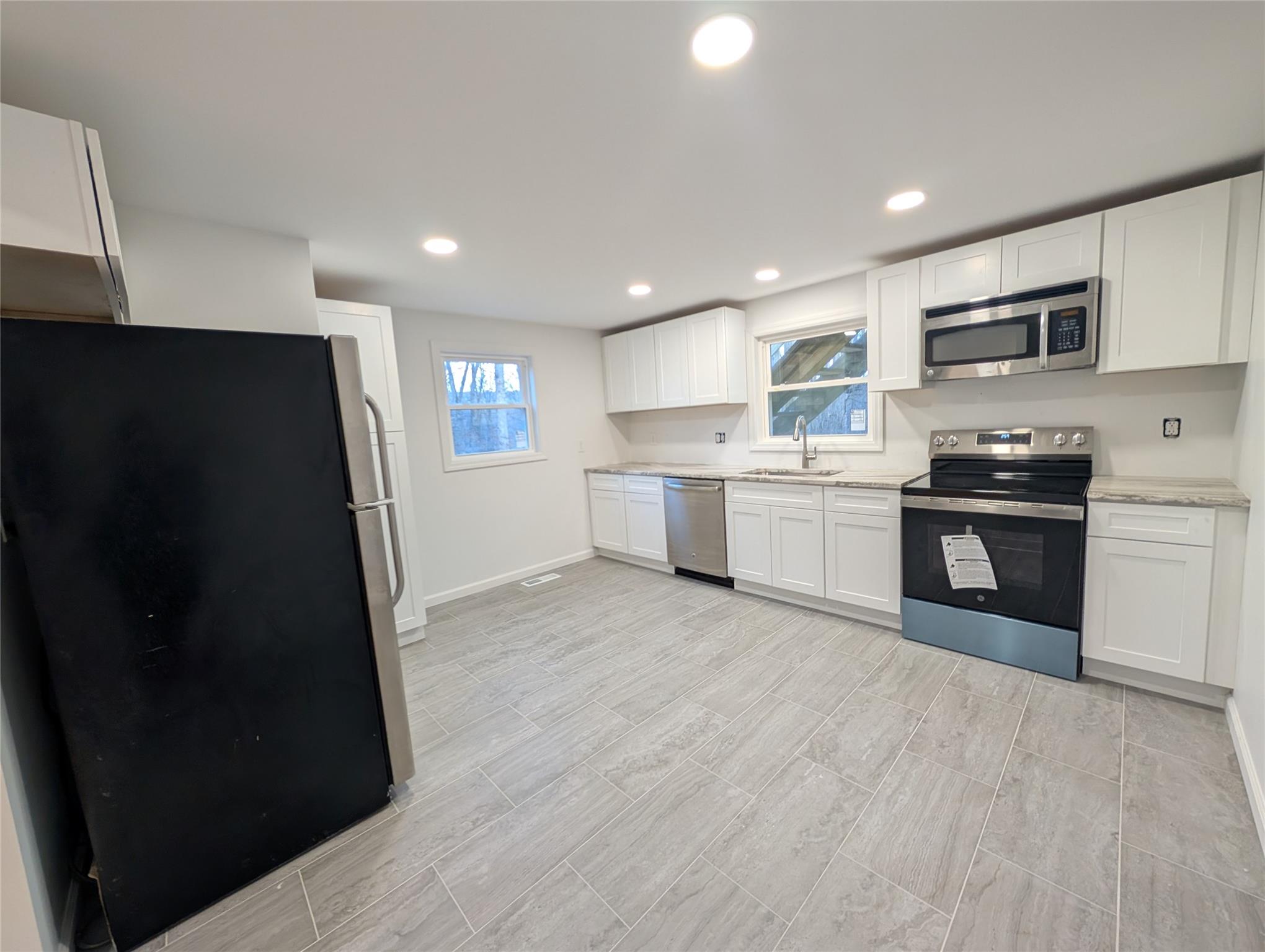 Kitchen featuring white cabinetry, sink, and stainless steel appliances