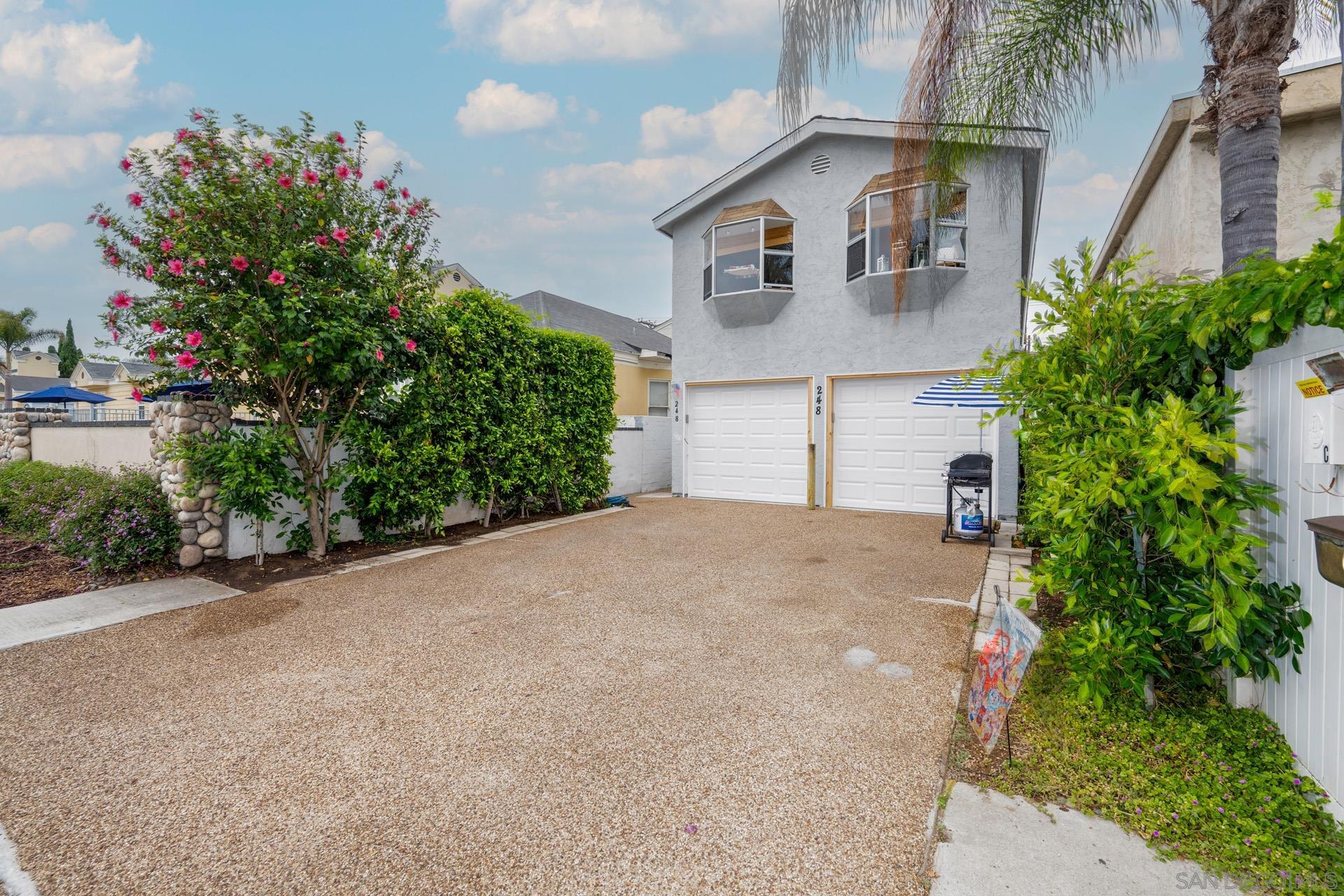 front view of a house with a yard and potted plants