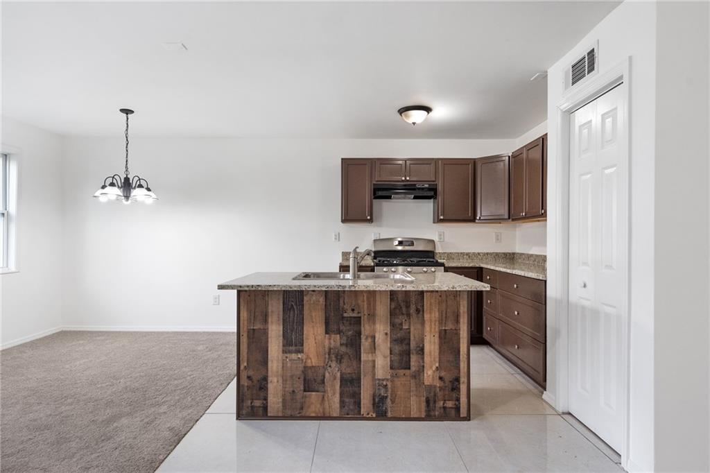 a kitchen with stainless steel appliances granite countertop a stove and a sink