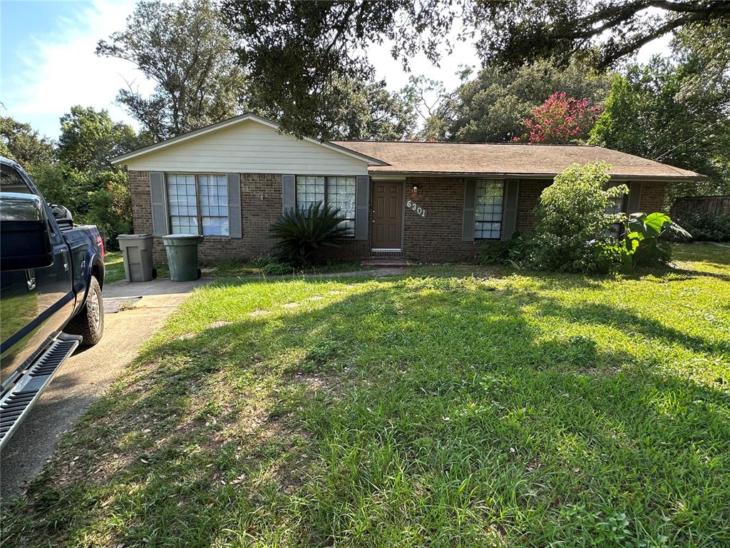 a front view of a house with a yard and trees