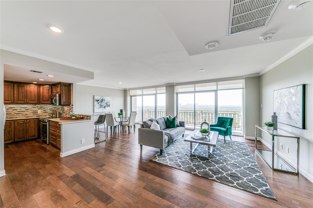 a large living room with kitchen island granite countertop a large window and stainless steel appliances