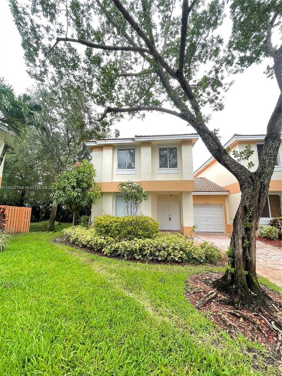 a front view of house with yard and green space