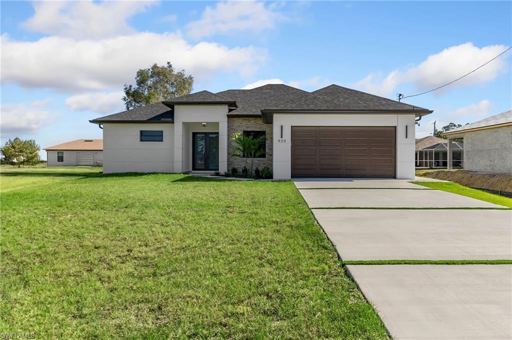 View of front of house featuring a front yard and a garage