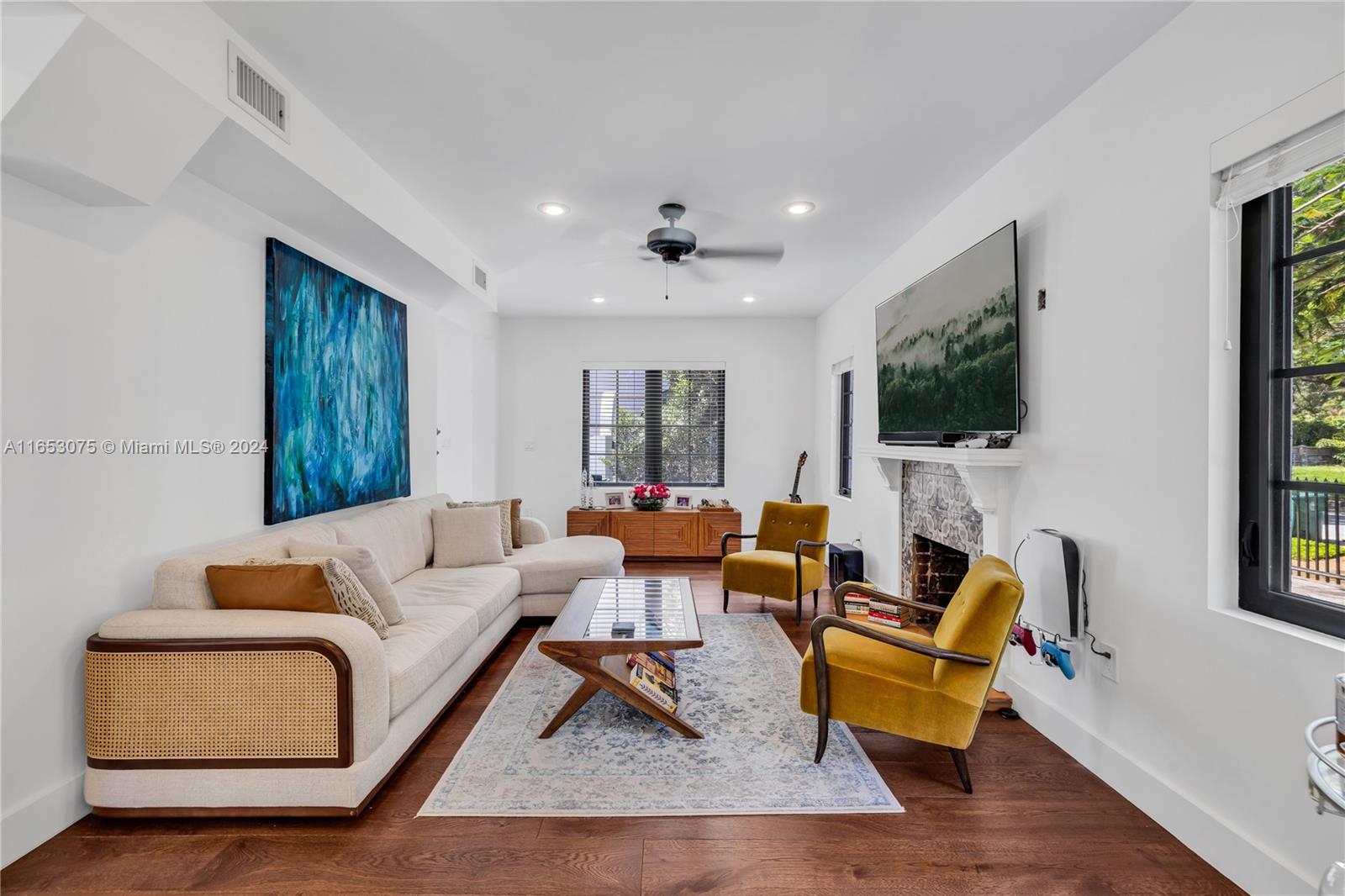 a living room with furniture wooden floor and a flat screen tv