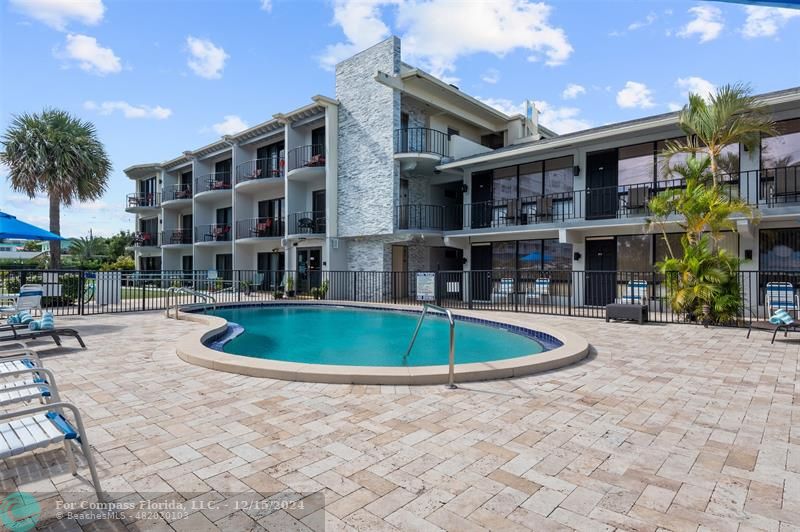 a view of a building with a swimming pool and sitting area