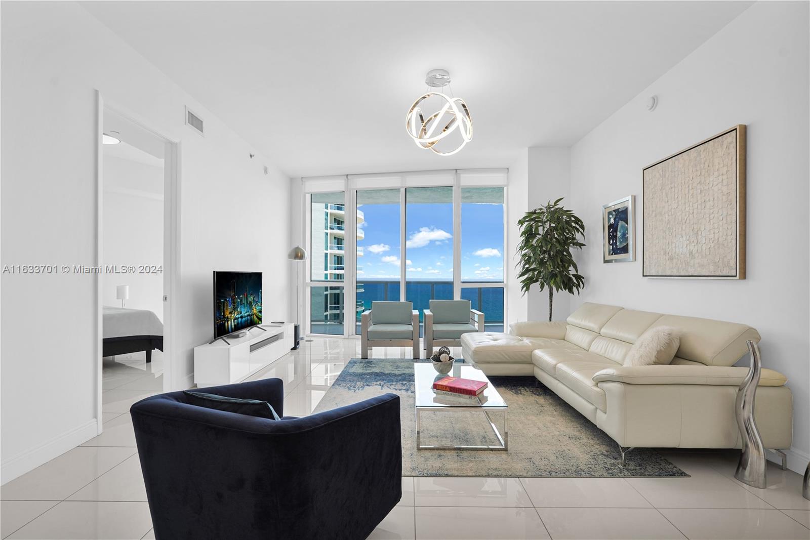 a living room with furniture potted plant and a flat screen tv