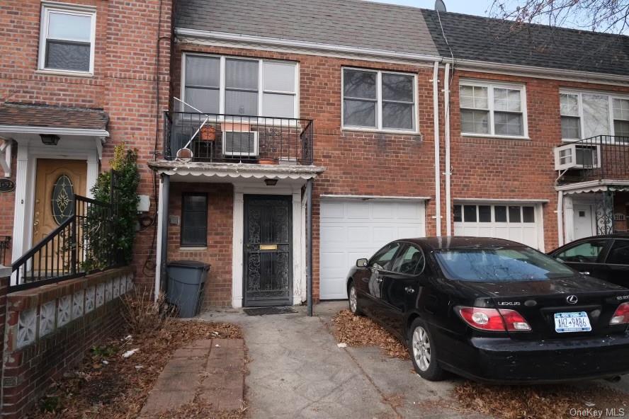 Rear view of house with a garage and a balcony