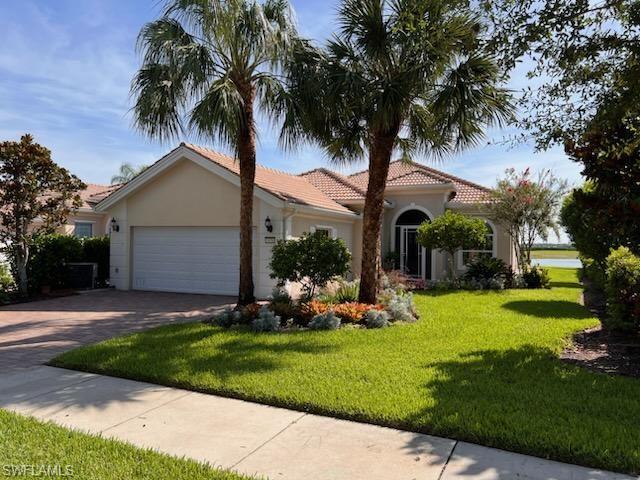 a front view of a house with garden and tree