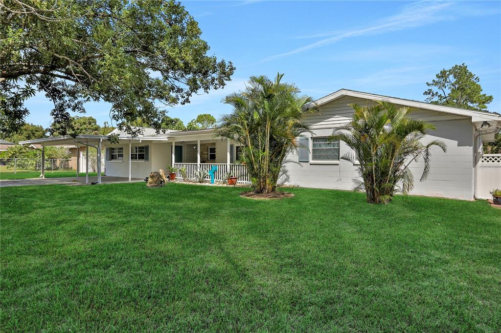 a view of house with yard and outdoor seating