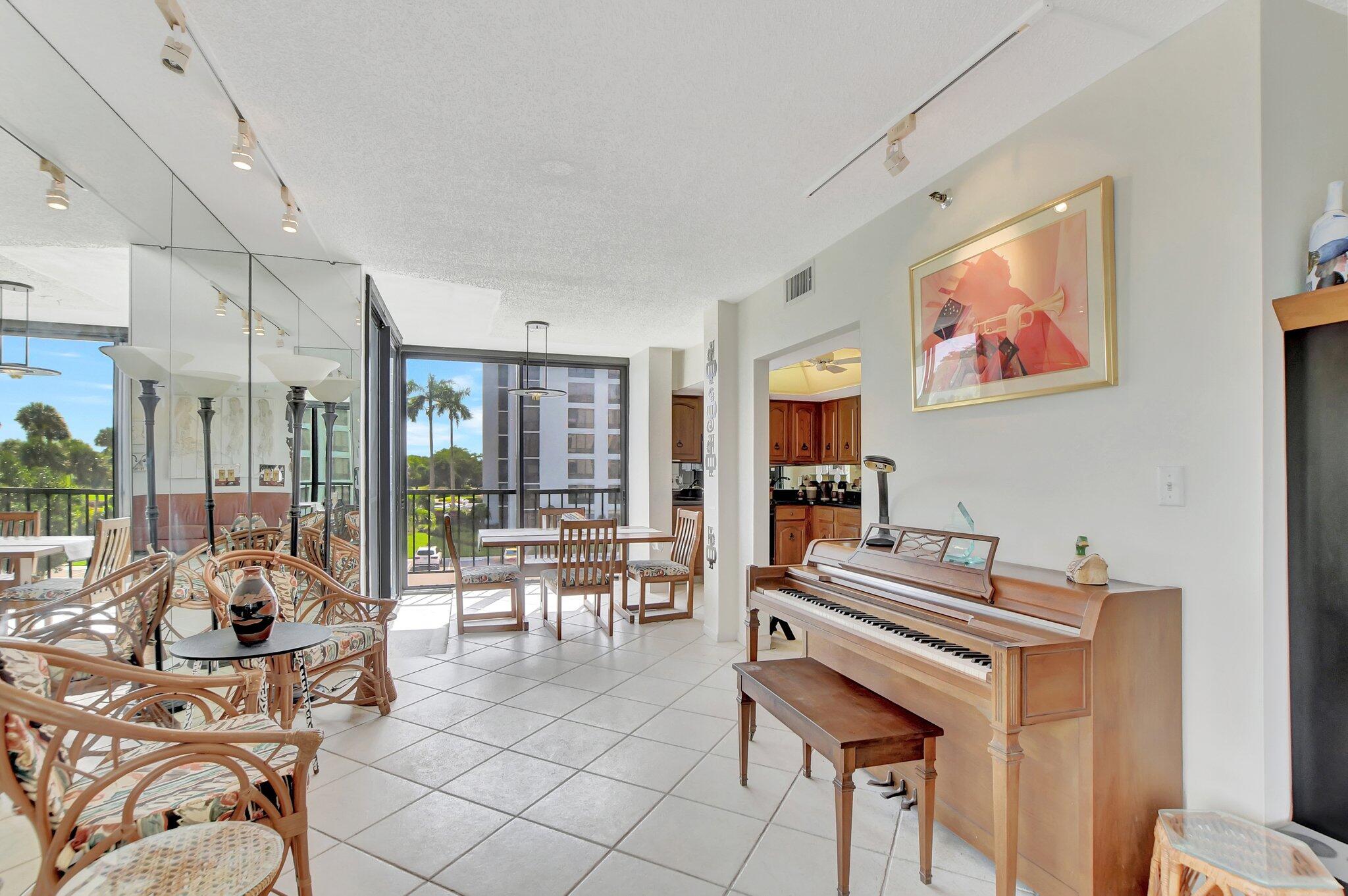 a living room with furniture a piano and a flat screen tv