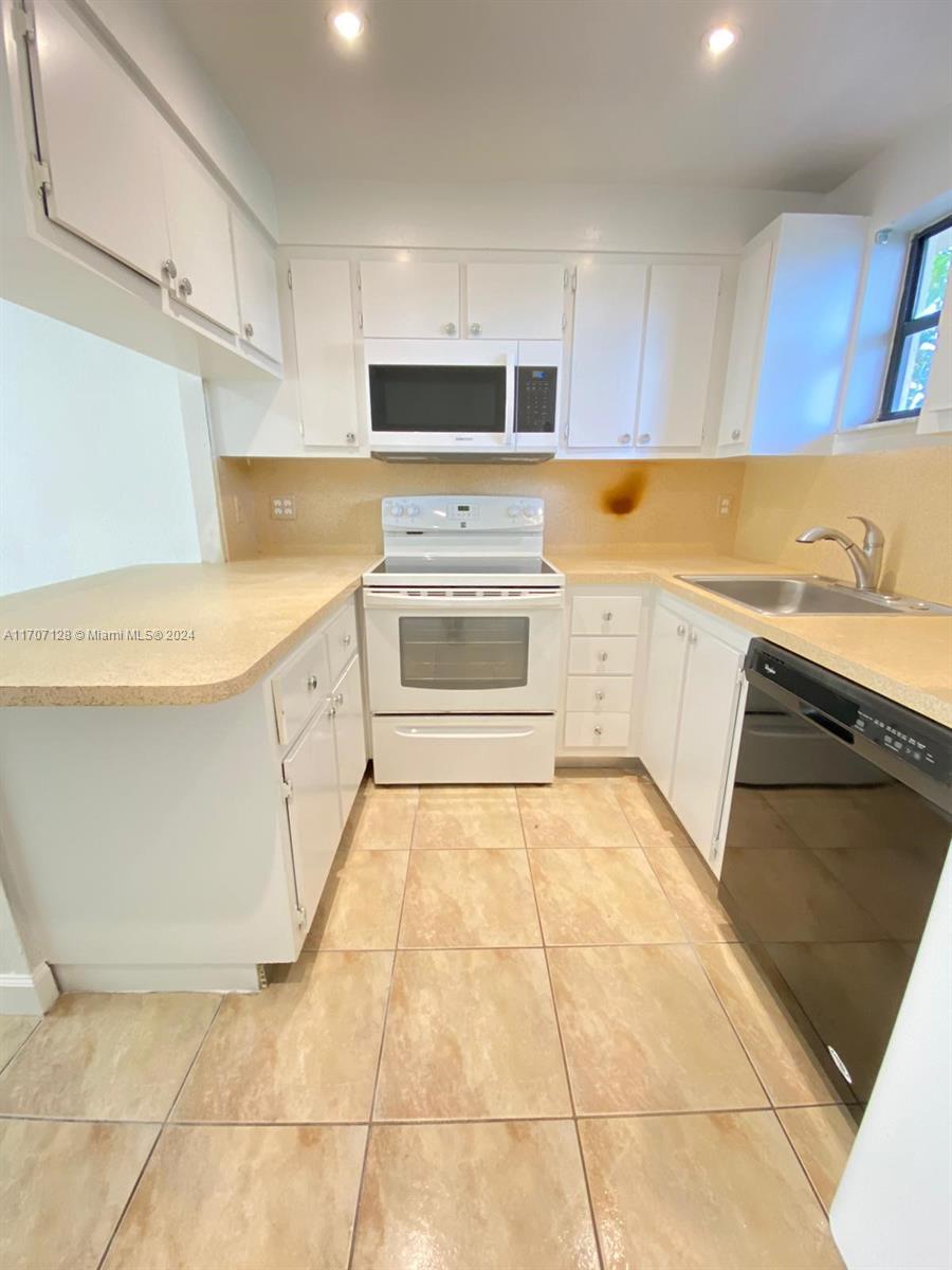 a kitchen with a stove top oven sink and cabinets