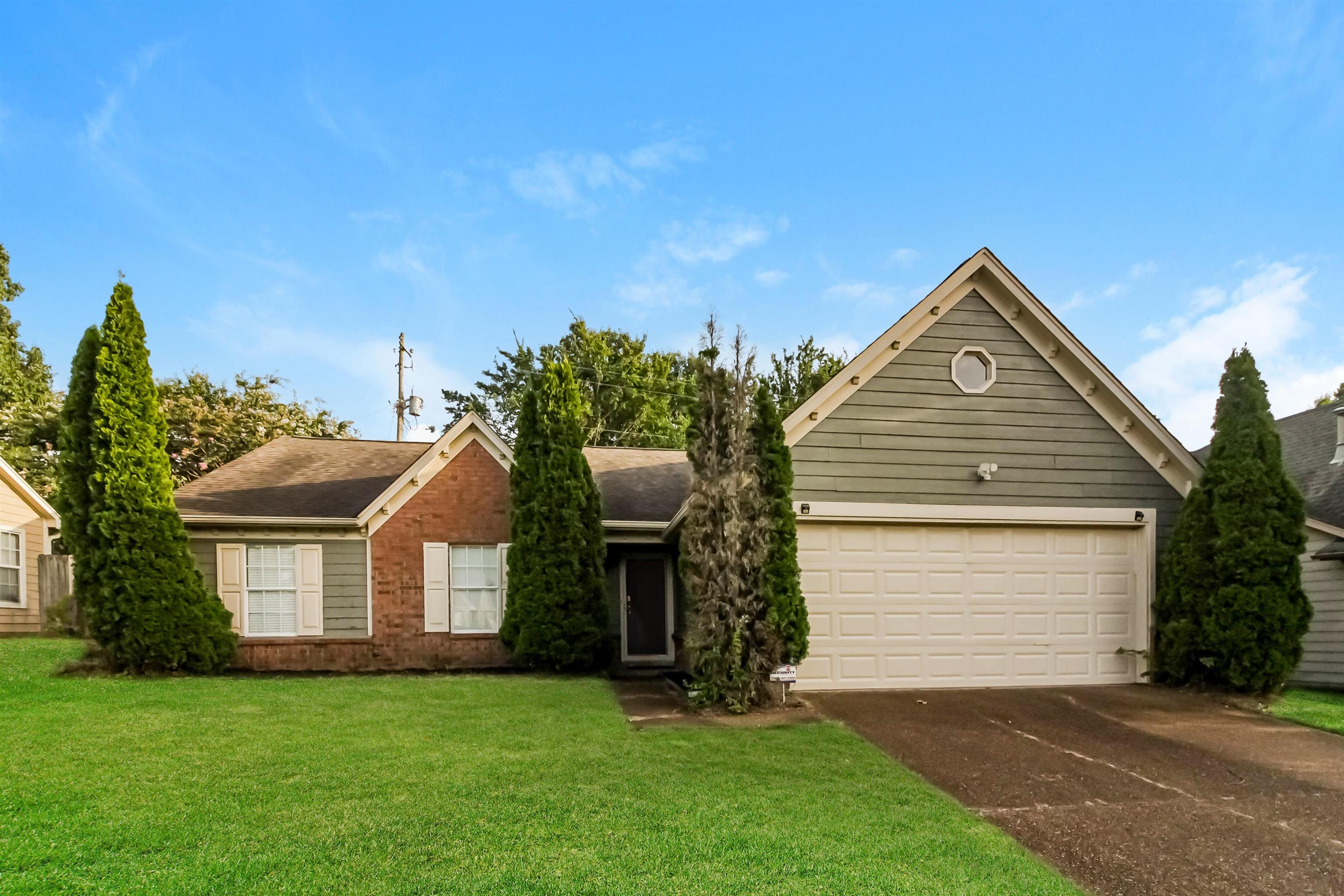 a front view of a house with a garden and yard