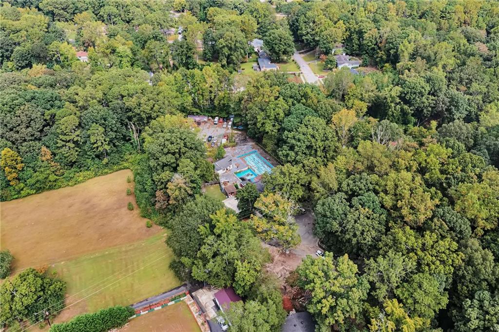 an aerial view of residential house with outdoor space and trees all around