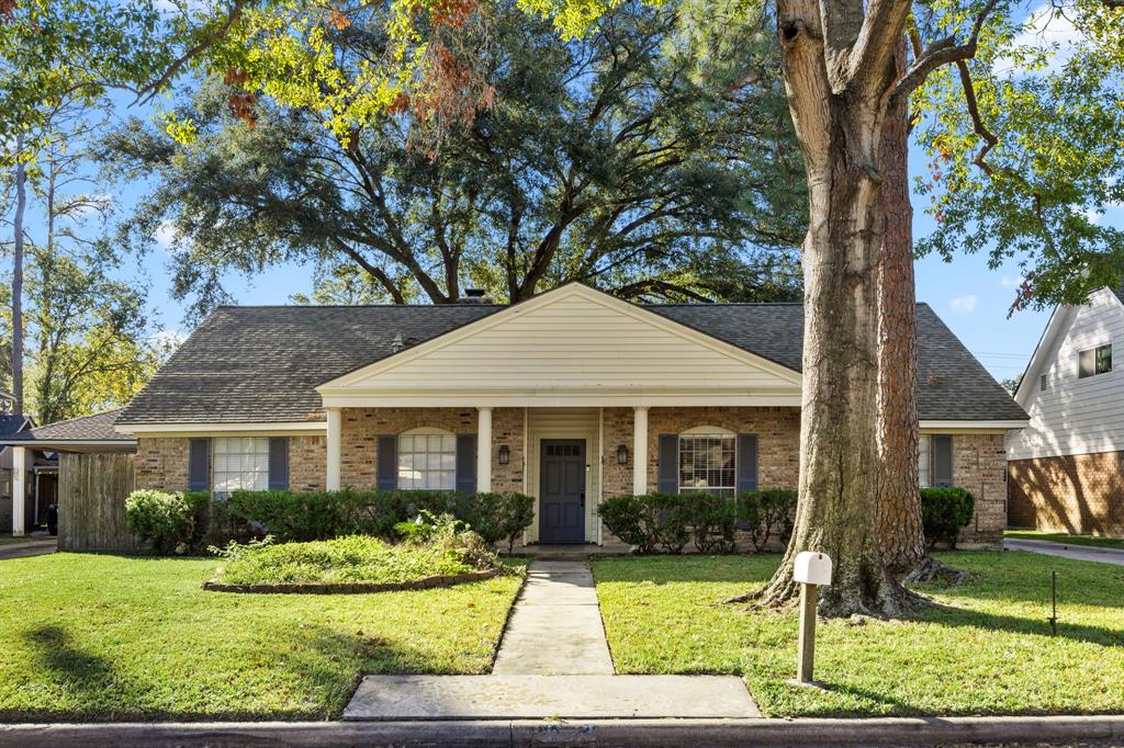 a front view of a house with yard and green space