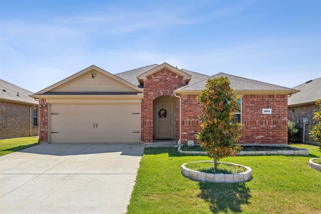 a front view of a house with a yard and a garage