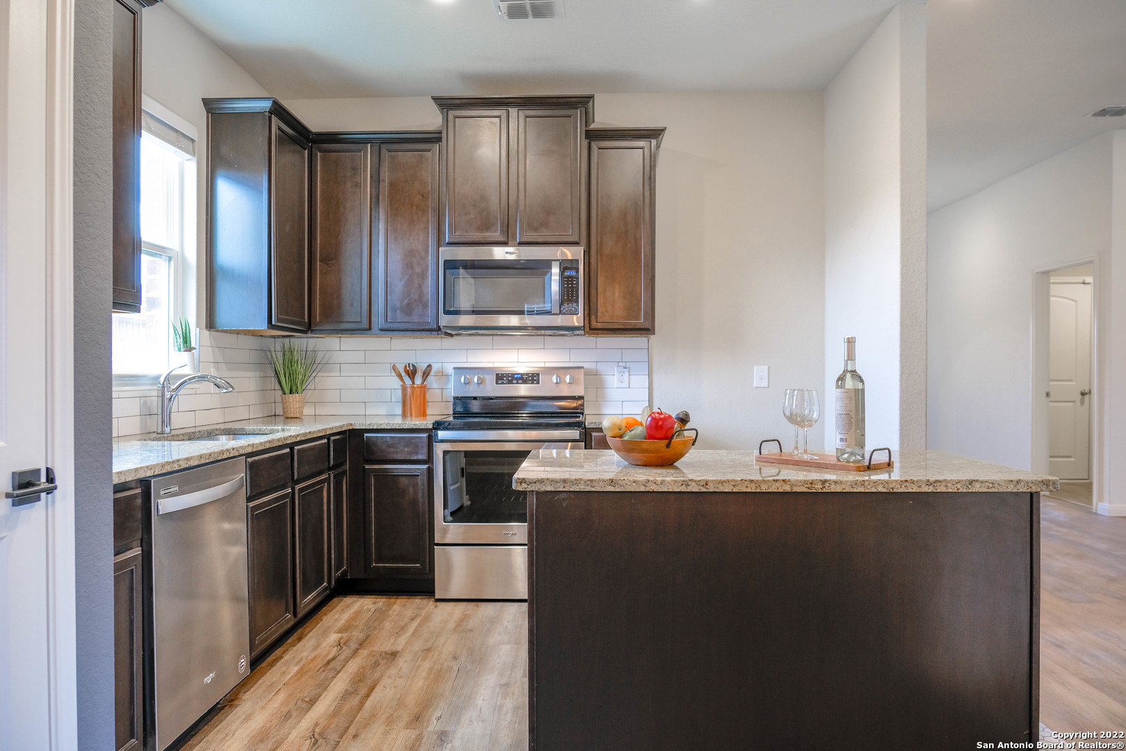 a kitchen with stainless steel appliances granite countertop a sink stove and refrigerator