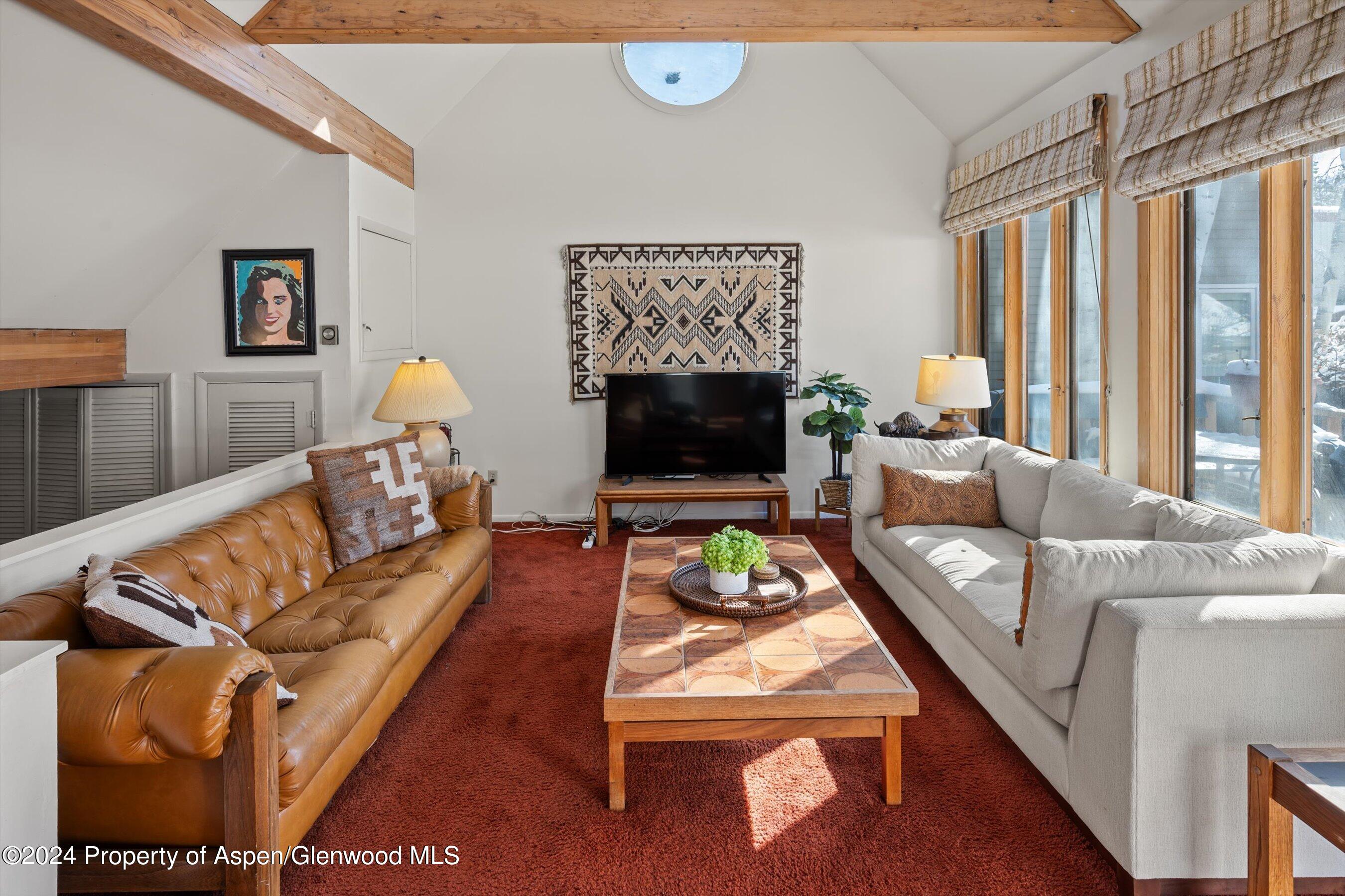 a living room with furniture a rug and a flat screen tv