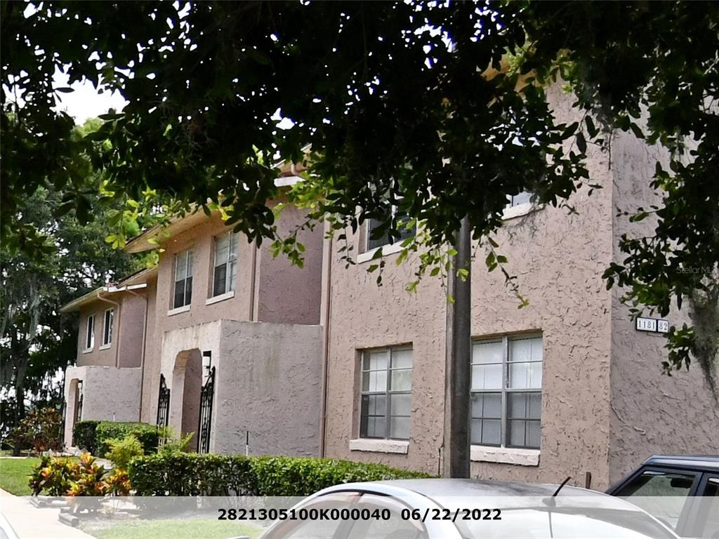 a front view of a house with a tree