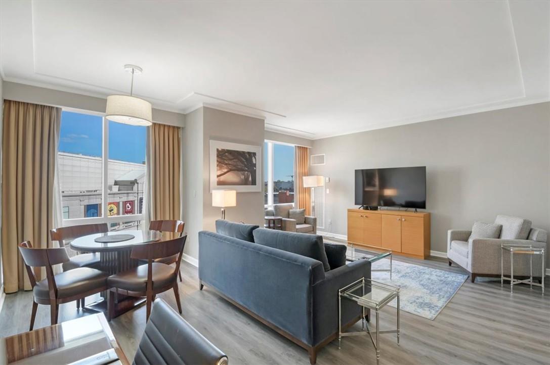 a living room with furniture a flat screen tv and a large window