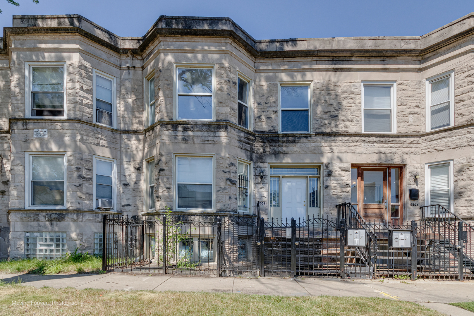 a front view of a residential apartment building with a yard