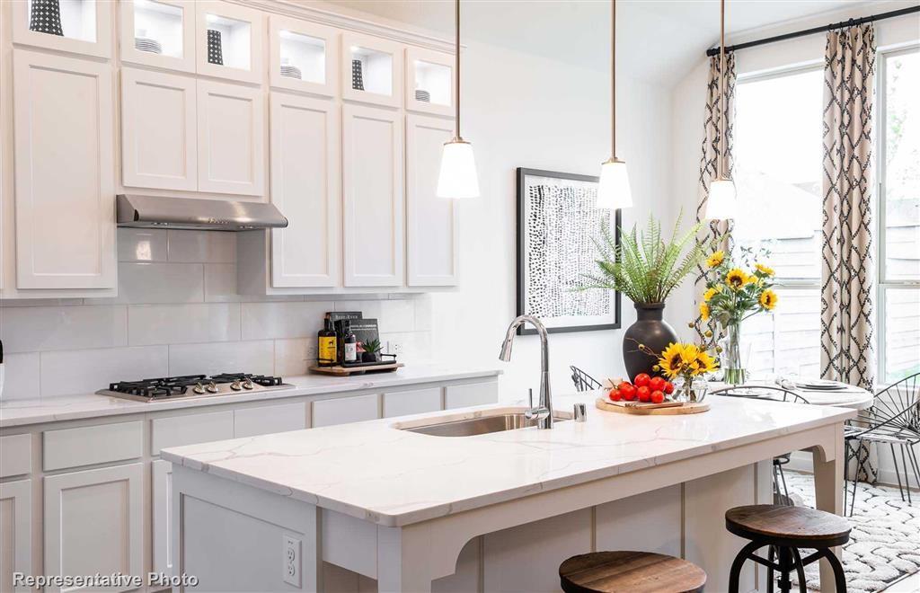 a kitchen with stainless steel appliances a sink a table and a view of living room