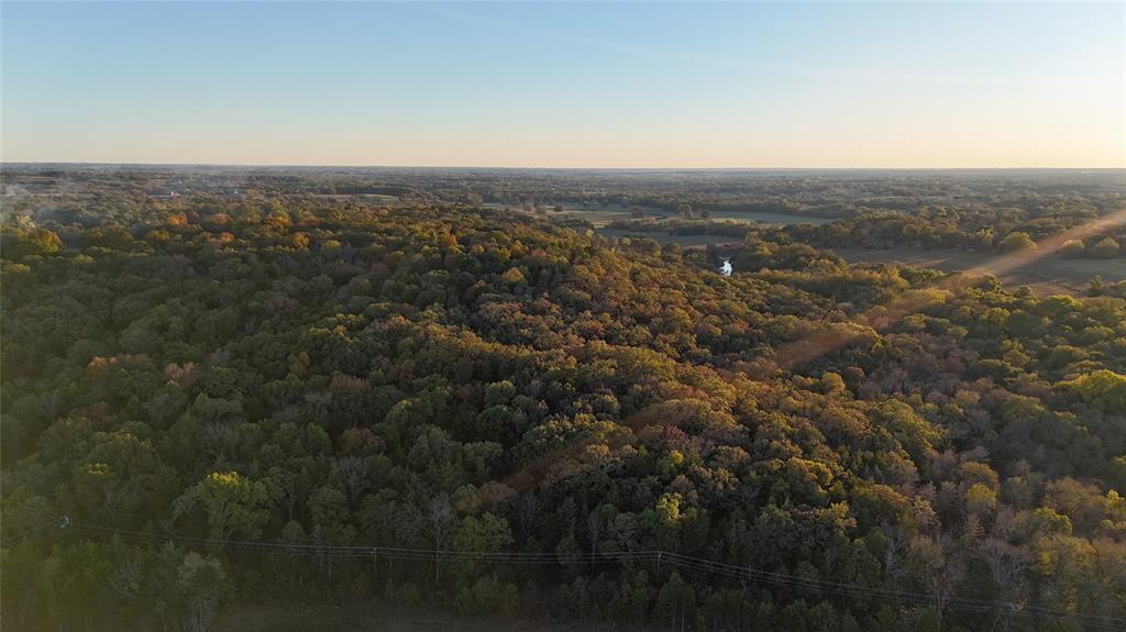 an aerial view of house with yard and mountain view in back