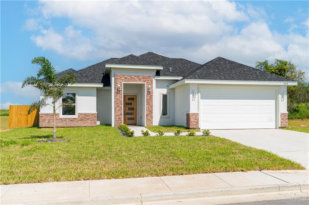 a front view of a house with a yard and garage