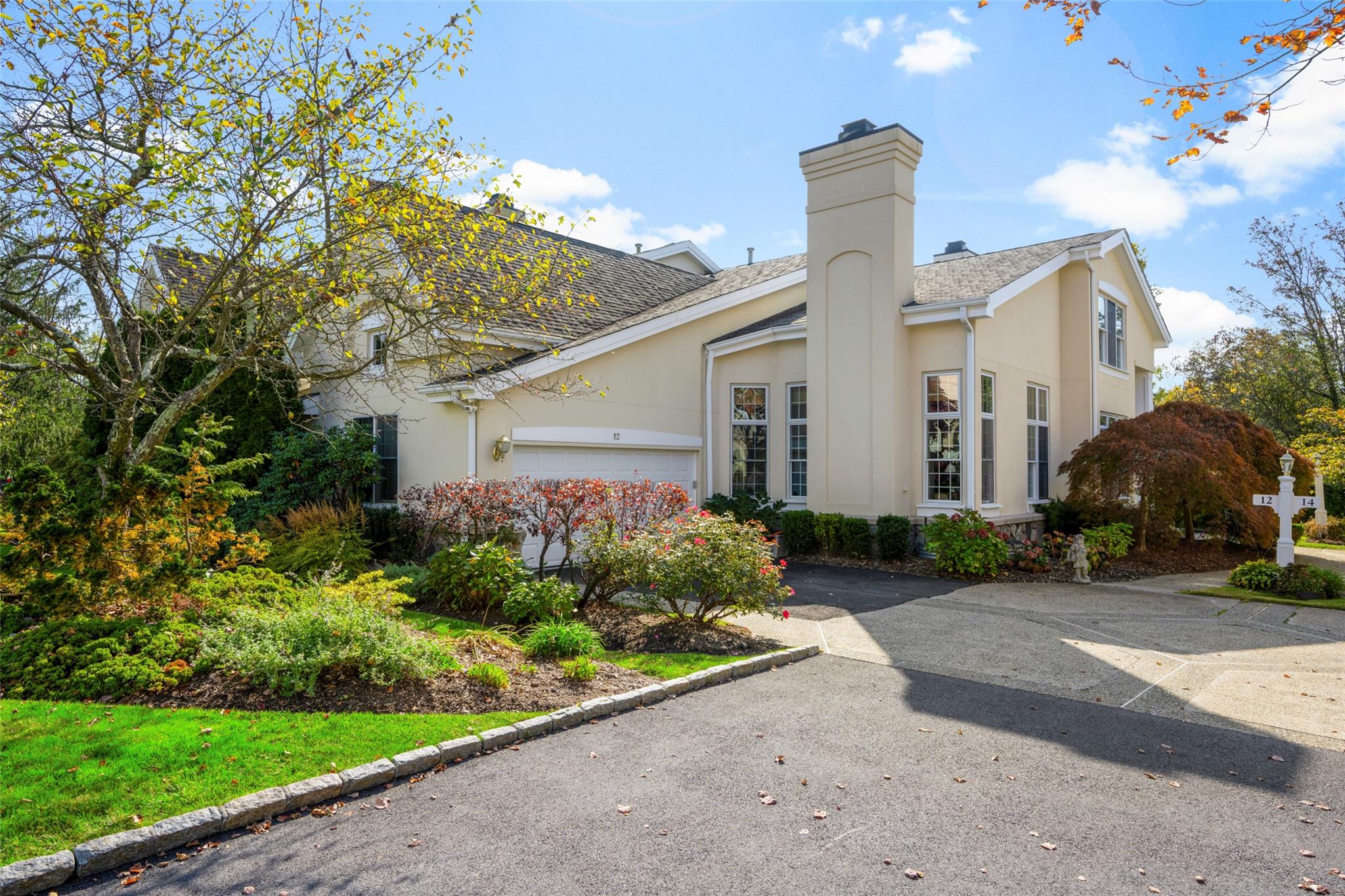 a front view of a house with garden and plants