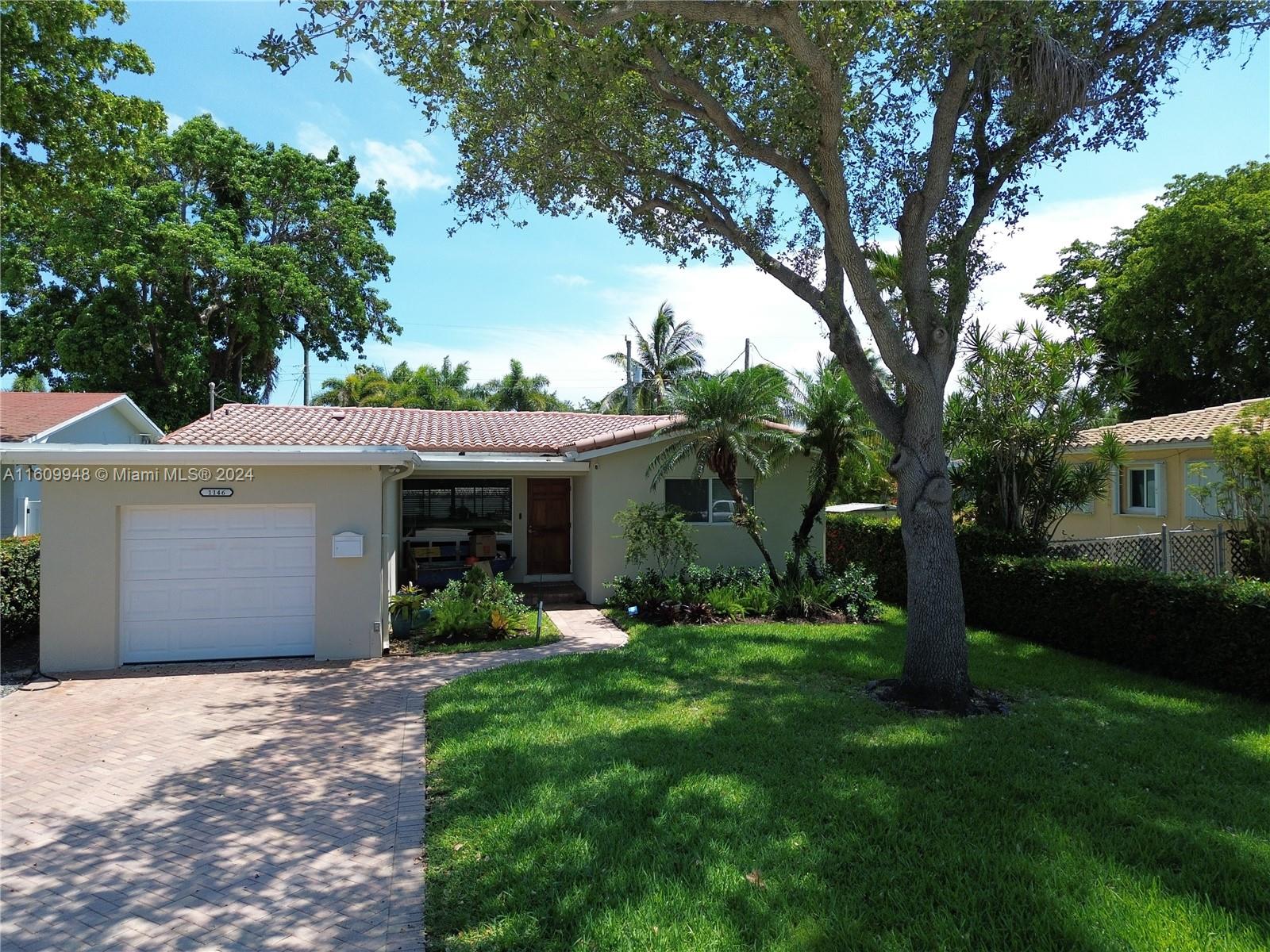 a view of a house with a yard and tree