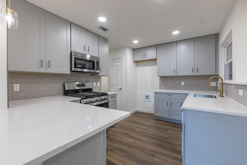 a kitchen with a sink a stove a microwave and cabinets